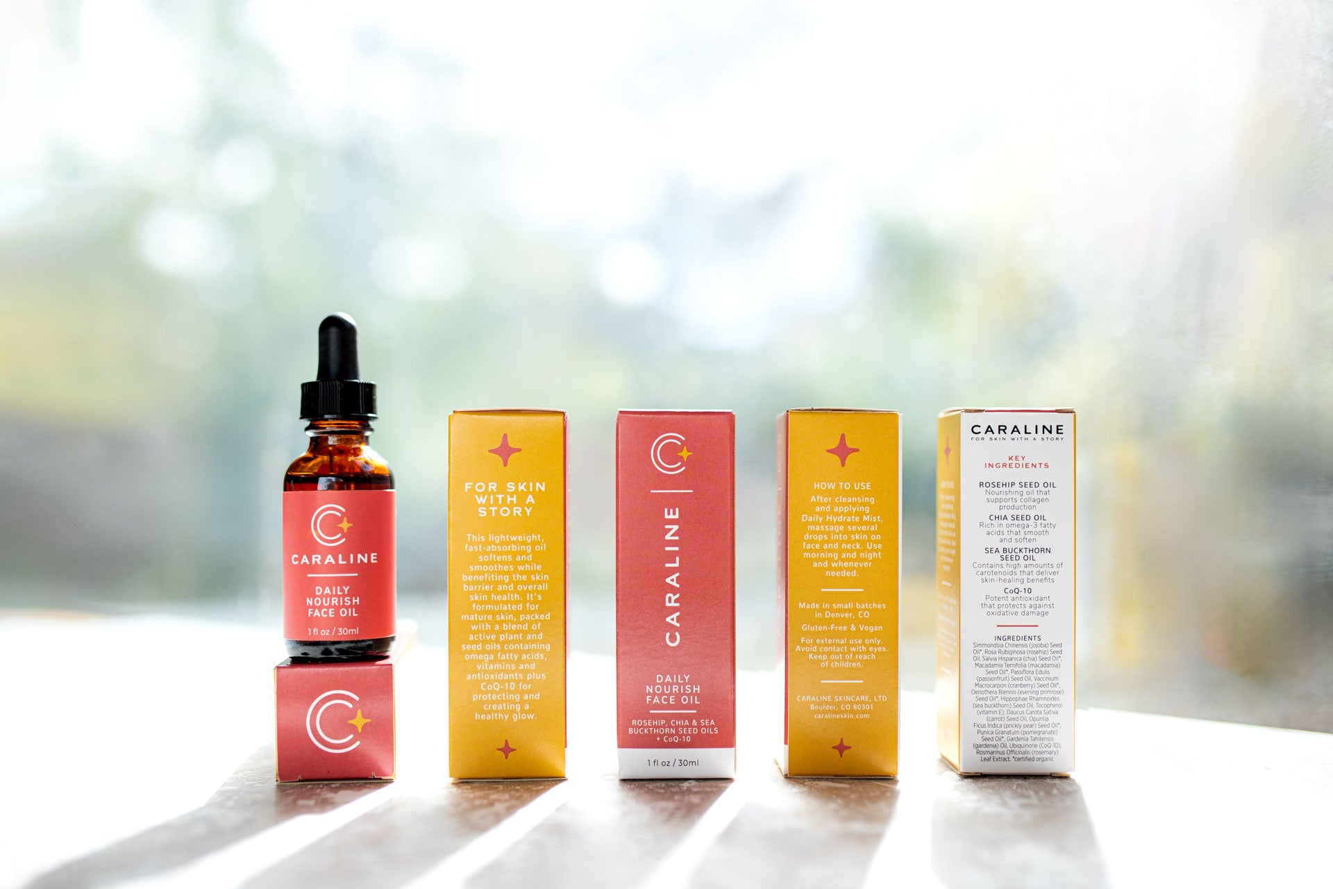 Caraline Skincare Daily Nourish Face Oil in a bottle with multiple cartons showing each side of the carton