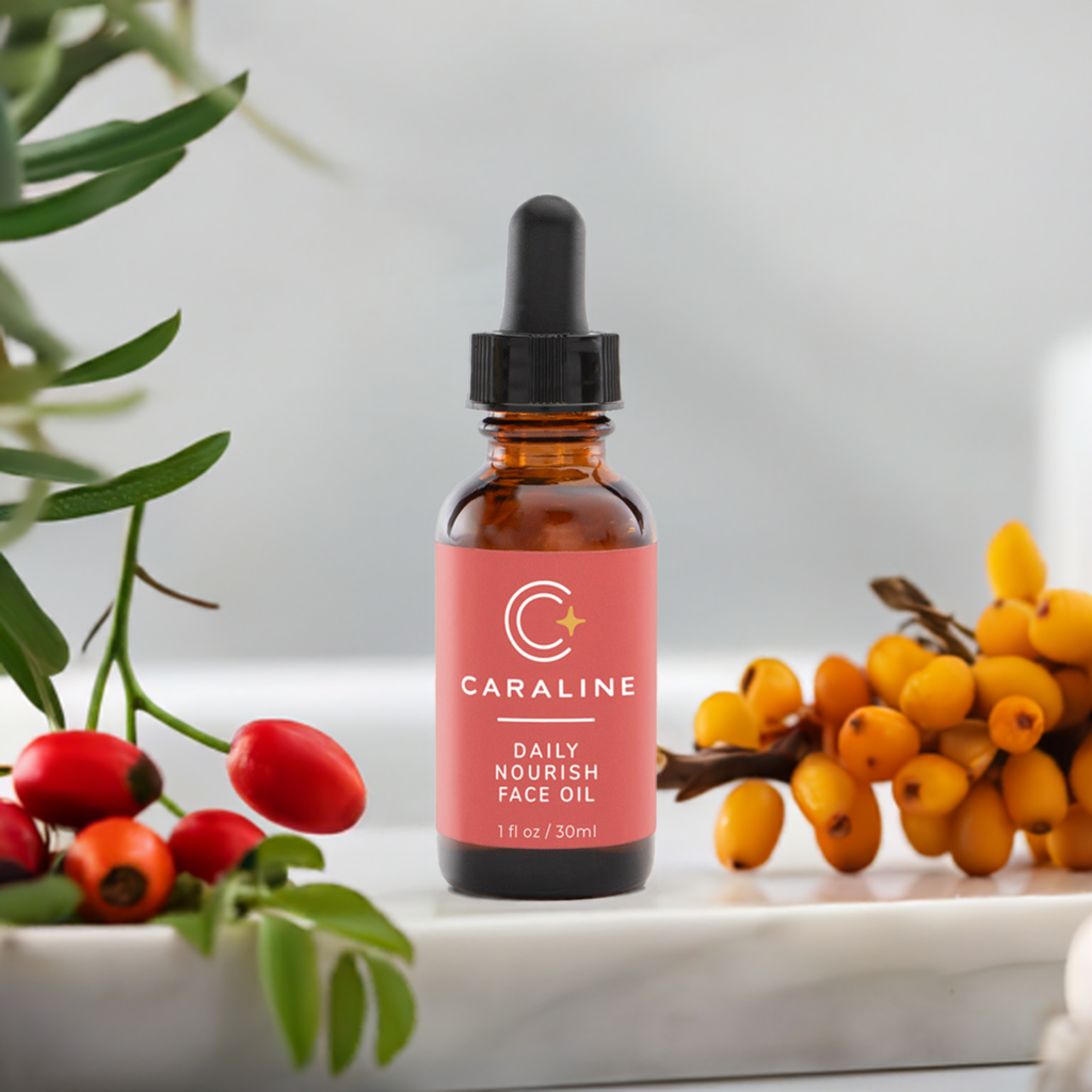 Bottle of Daily Nourish Face Oil on a marble surface with rosehips and sea buckthorn berries
