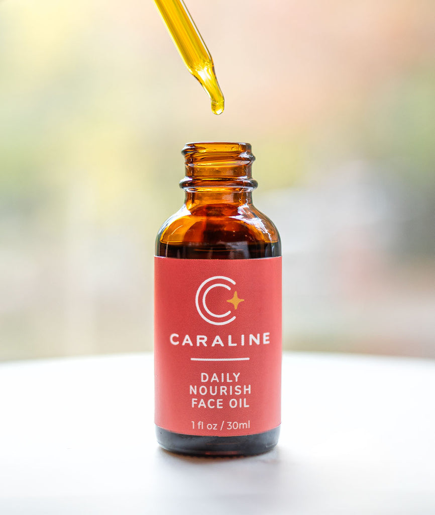 Caraline Skincare Daily Nourish Face Oil in a bottle with a dropper that shows the rich, golden color of the oil