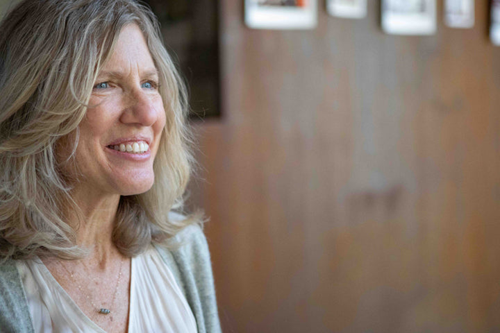 Attractive older woman with blond hair, smiling, looking away from the camera