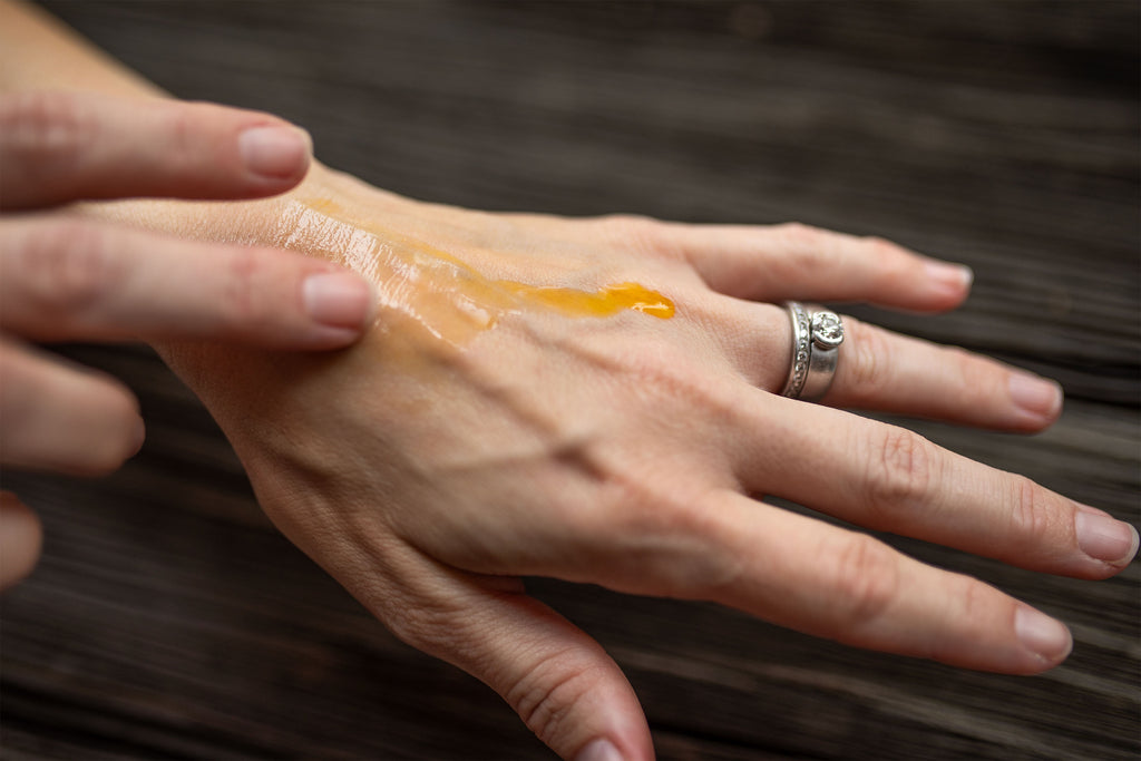 Caraline Skincare Daily Nourish Face Oil on the back of a hand being rubbed into the skin 